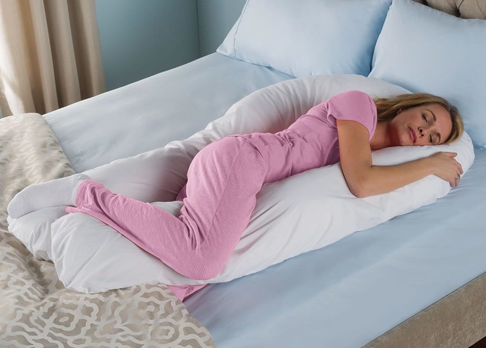 Pregnant woman using a full body pillow