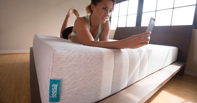 A woman laying on her stomach on a Leesa Mattress