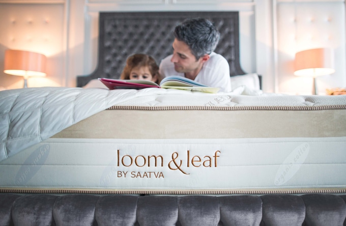 A father and daughter reading on their loom and leaf bed