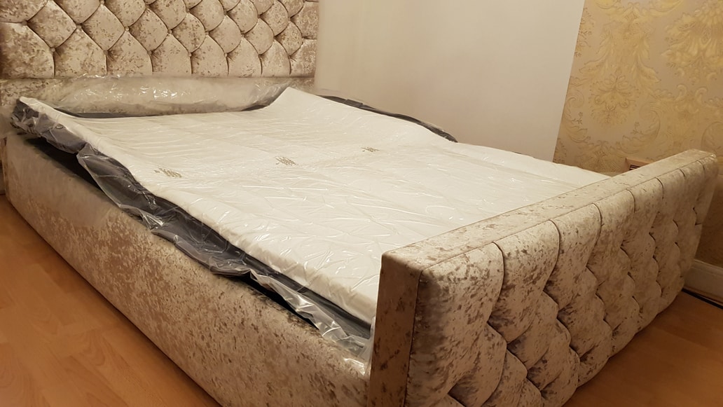 A vacuum sealed and unrolled mattress on a bed