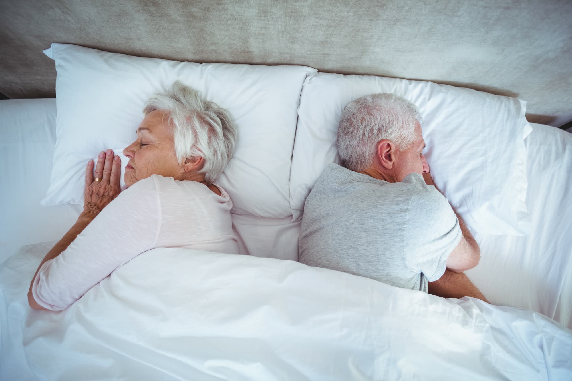 Overhead view of senior couple sleeping on bed