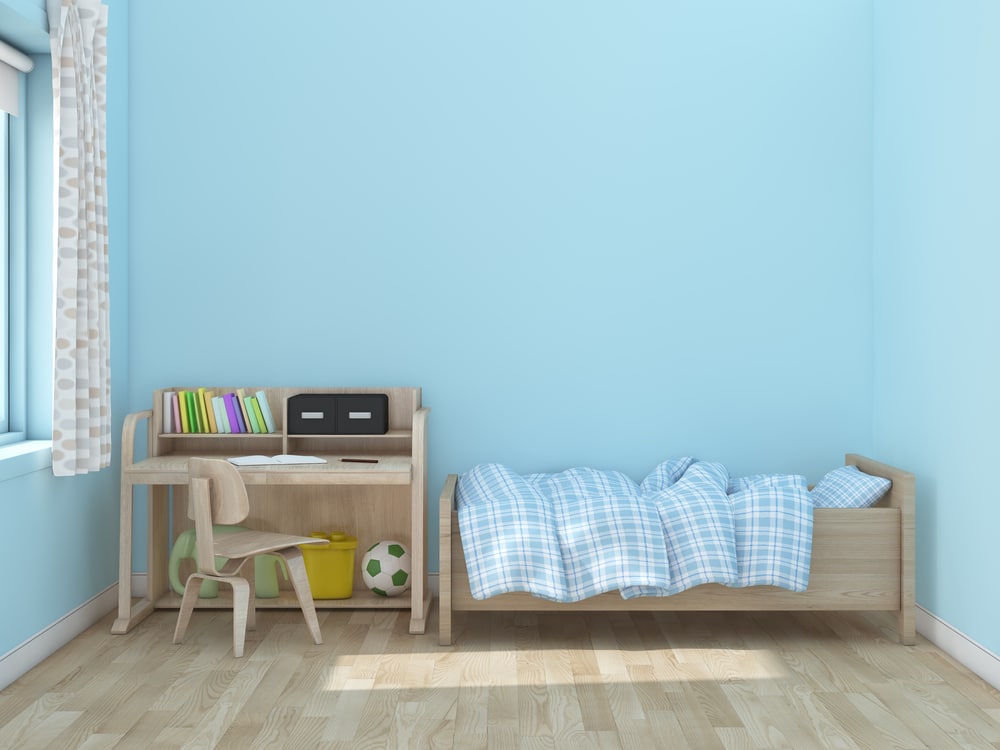 A toddler bed with blue sheets